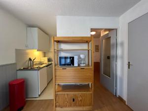 a small kitchen with a microwave and a small kitchen with a counter at Appartement Pra-Loup, 2 pièces, 4 personnes - FR-1-165A-82 in Uvernet