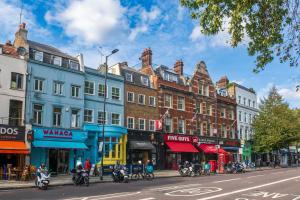 ロンドンにあるModern Spacious Apartment in Islingtonの多くのショップや建物が並ぶ賑やかな街道