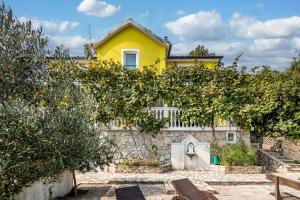 a yellow house with trees in front of it at Seaview House Helena Apartments - Happy Rentals in Plomin