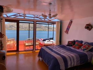 a bedroom with a bed and a view of the water at Uros Titicaca Mallku lodge in Puno