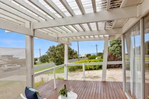 een witte pergola op een terras met uitzicht op het strand bij Great Ocean Road Sandy Villa in Apollo Bay