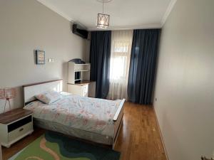 a small bedroom with a bed and a window at Cozy & Spacious Apartment in Baku