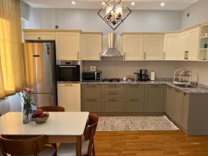 a kitchen with a table and a dining room at Cozy & Spacious Apartment in Baku