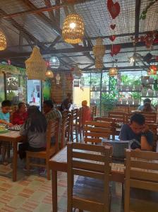 a group of people sitting at tables in a restaurant at Sealey's Inn in Sipalay