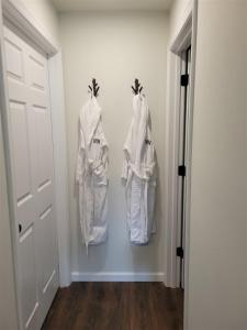 a hallway with three white robes hanging on a wall at Hunters Haven in Luray