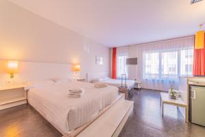 里昂Residence Montempo Lyon Cite Internationale的卧室里有一张白色的大床和一张桌子 更多34张照片