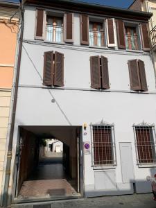 un edificio blanco con persianas marrones y una puerta en Appartamento Luce-- 2 camere da letto--Centro storico--Parcheggio privato gratuito, en Lugo