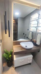 a bathroom with a sink and a mirror at Apartamento calmo e aconchegante in Florianópolis