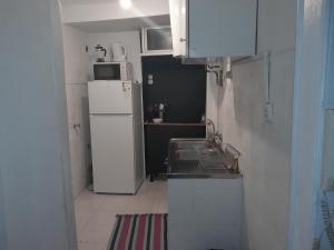 a small kitchen with a sink and a refrigerator at Chiado / Carmo Small Artist Lodge in Lisbon