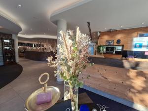 a vase of flowers on a table in a restaurant at Business Class Hotel Ebersberg in Ebersberg