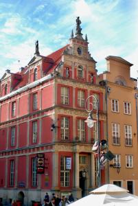 a large red building with a clock on it at Dom Schumannów in Gdańsk