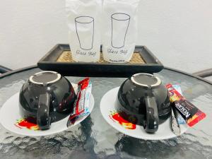 two cups on plates on a glass table at Lanta Grand House in Ko Lanta