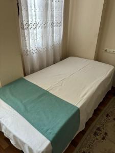 a small bedroom with a bed with a window at Efe Can Apart Otel in Çanakkale