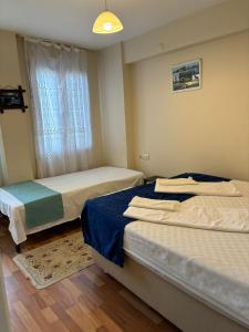 a bedroom with two beds and a window at Efe Can Apart Otel in Çanakkale