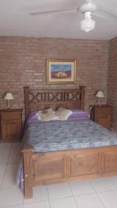 1 dormitorio con 1 cama grande de madera y 2 mesitas de noche en Cabañas El Molinillo en Nono