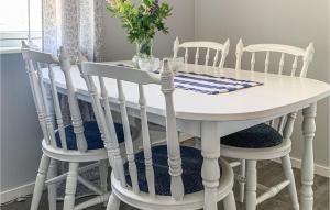een witte eettafel met vier stoelen eromheen bij Beautiful Home In Vstervik With Wifi in Västervik