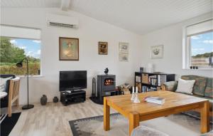 - un salon avec une table et une cheminée dans l'établissement 3 Bedroom Stunning Home In Rudkbing, à Spodsbjerg