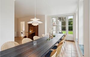 a dining room with a large wooden table and chairs at Awesome Home In Haslev With Kitchen in Haslev