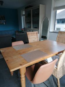 a wooden table in a kitchen with chairs at TypisGistel in Gistel