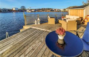 a wooden deck with a table and a vase on it at Amazing Apartment In Skrhamn With House A Mountain View in Skärhamn