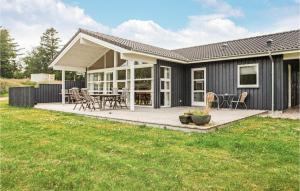 Casa con terraza con mesa y sillas en 4 Bedroom Gorgeous Home In Nykbing Sj, en Højby
