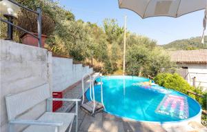 uma piscina num quintal com um guarda-sol em Lovely Home In Marliana With House A Panoramic View em Marliana