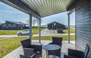 porche cubierto con mesa, sillas y coche en Cozy Home In Haderslev With Wifi, en Diernæs