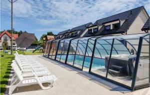 a house with a glass extension with chairs and a pool at Stunning Home In Jantar With Heated Swimming Pool in Jantar