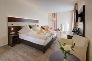 a hotel room with a large bed and a table at Concorde Hotel am Leineschloss in Hannover