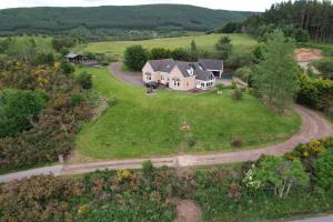 an aerial view of a house on a green field at The Gables Whisky B&B in Dufftown