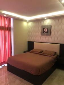 a bedroom with a bed and a red curtain at مشروع ميريت البحر الميت السكني العائلي in Sowayma