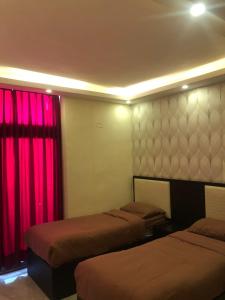 a room with two beds and red curtains at مشروع ميريت البحر الميت السكني العائلي in Sowayma