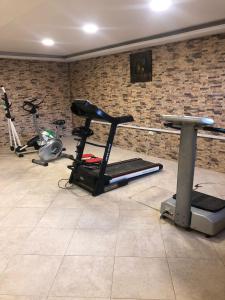 a gym with a treadmill and two exercise bikes at مشروع ميريت البحر الميت السكني العائلي in Sowayma