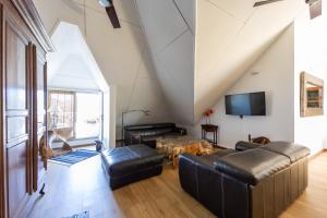 ein Wohnzimmer mit Ledermöbeln und einem TV in der Unterkunft Rooftop - magnifique penthouse proche du lagon de l Hermitage-Les-Bains in L'Ermitage-Les-Bains