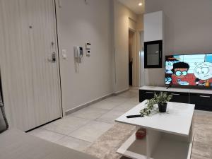 - un salon avec une télévision et une table blanche dans l'établissement PanoramicView180 1BR Welcome Stay Lux Penthouse Apartment, à Thessalonique