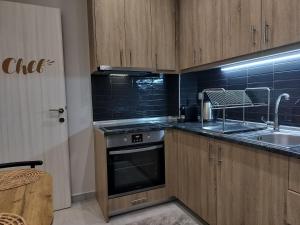 - une cuisine avec des placards en bois, un évier et une cuisinière dans l'établissement PanoramicView180 1BR Welcome Stay Lux Penthouse Apartment, à Thessalonique