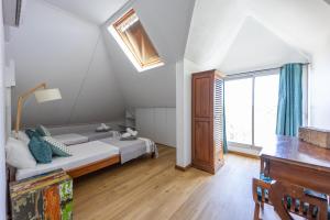 ein Schlafzimmer mit einem Bett und einem großen Fenster in der Unterkunft Rooftop - magnifique penthouse proche du lagon de l Hermitage-Les-Bains in L'Ermitage-Les-Bains