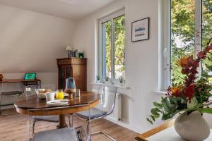 a dining room with a table and chairs and windows at Apartment Wilhelm in Nienburg