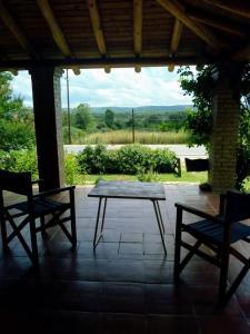 una mesa de madera y 2 sillas en el patio en Cabañas El Molinillo en Nono