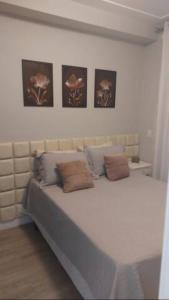 a bed in a room with four pictures on the wall at PHD - Personal Home Design in Sao Paulo