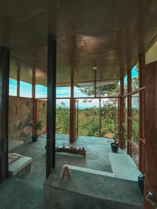 um quarto com uma grande janela de vidro e uma banheira em Villa Zalakain em Siquijor