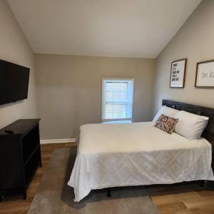 a bedroom with a bed and a flat screen tv at Stylish Cottage Near Airport in Atlanta