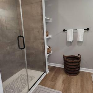 a shower with a glass door in a bathroom at Stylish Cottage Near Airport in Atlanta