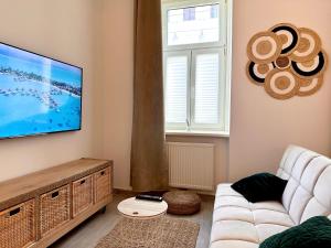sala de estar con sofá blanco y TV de pantalla plana en Loft Apartment am Brunnenmarkt en Viena