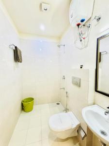 a white bathroom with a toilet and a sink at Hotel Panchsheel inn in Ajmer