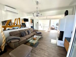 a living room with a couch and a tv at Villa Iduna mit modern desingten Apartments in Graal-Müritz