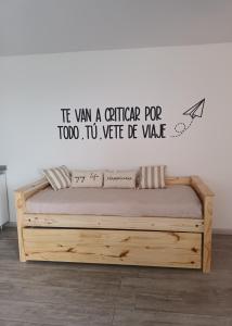 El Challao的住宿－Departamento espectacular vista a la Ciudad，卧室配有一张挂有墙上标志的床
