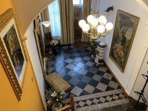 a hallway with a staircase with paintings on the walls at Gite de Caractère Le Lys Bleu in Limbourg