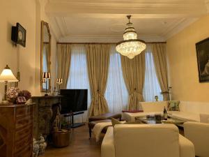 ein Wohnzimmer mit einer Couch und einem Kronleuchter in der Unterkunft Gite de Caractère Le Lys Bleu in Limbourg + 37 Fotos