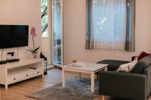 a living room with a tv and a couch and a table at Bell Tower Apartment in Mostar